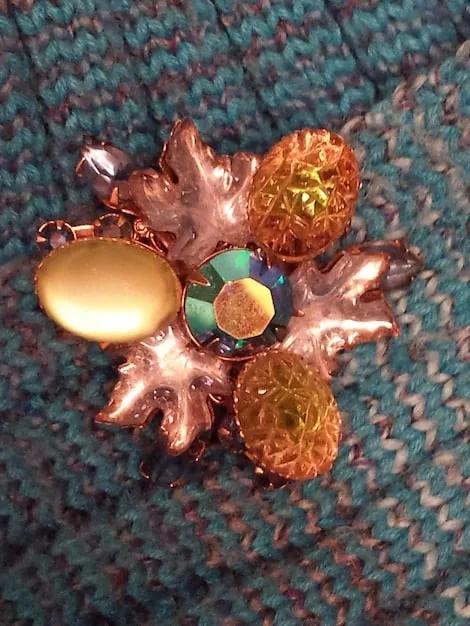 A detailed flat lay of various mixed-metal jewelry (gold, silver, rose gold) alongside different colored gemstones, illustrating versatility and eclectic style.