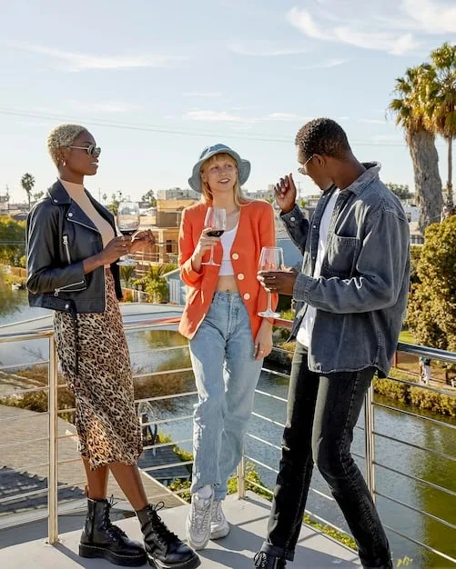 A diverse group of people at a sophisticated cocktail party, dressed in various stylish cocktail attire, reflecting modern fashion trends.