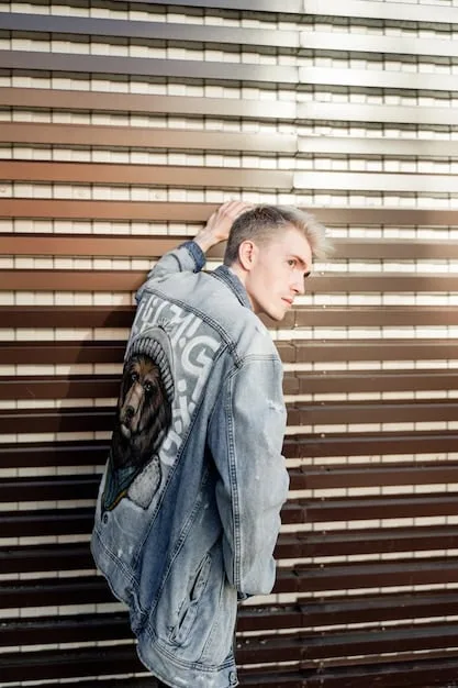 A close-up shot of a gender-neutral oversized denim jacket, worn by a person with a non-binary presentation, featuring subtle distressed details and a relaxed fit, against an urban backdrop.