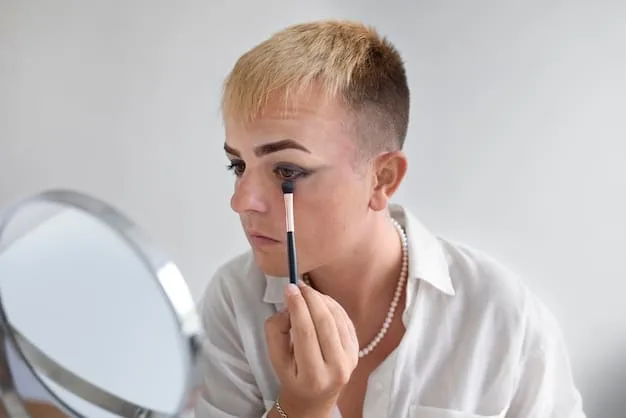 Close-up of a person applying an eyeshadow primer to their eyelid, showing a smooth, even application.