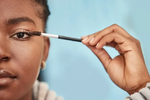 A person using a clear brow gel to brush up their eyebrows, showing the final step of setting with a soft focus on the defined brow.