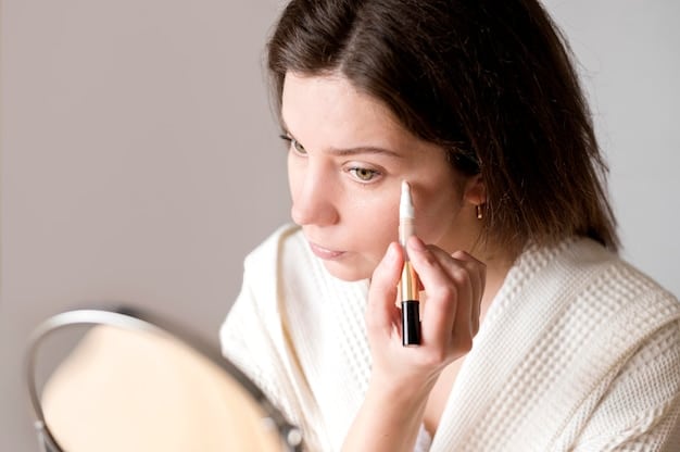 A close-up side profile of a woman's face, meticulously applying a clear gel primer with her fingertips, showing the natural texture of her skin being smoothed. Soft light from the side accentuates the even application.