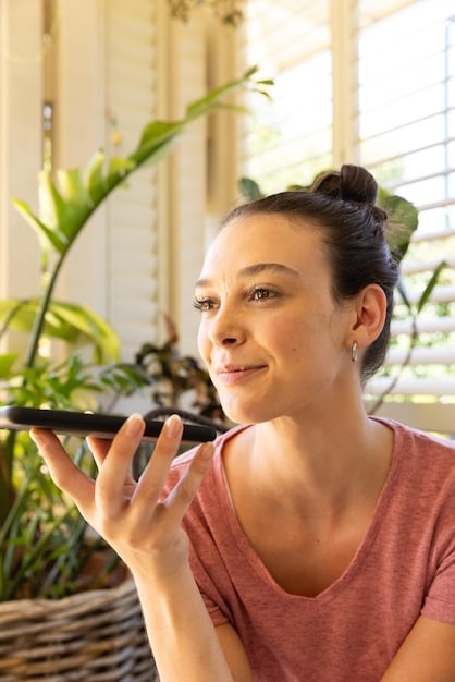 A woman applying foundation with a beauty blender in natural morning light, demonstrating proper application technique and good lighting practices.