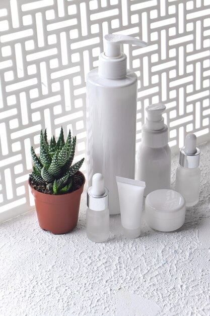 A variety of skincare products, including a cleanser, serum, and moisturizer, neatly arranged on a bathroom counter with soft ambient lighting.