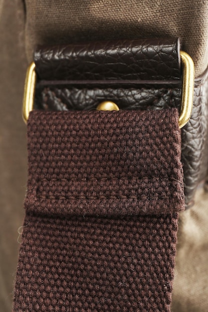 A close-up of various belt materials: polished black leather, distressed brown leather, rough canvas, and a vibrant woven fabric, showcasing their unique textures.